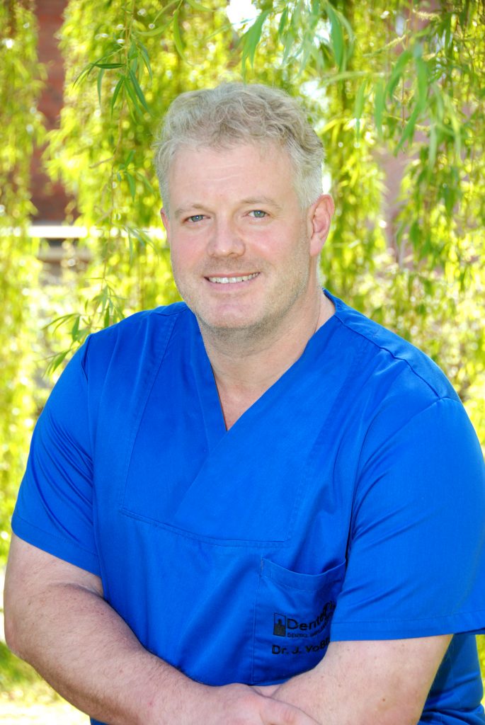 Dr. Jürgen Voßhans in blauer Praxiskleidung